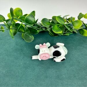 Vintage Black and White Cow Figurine Laying on Arm